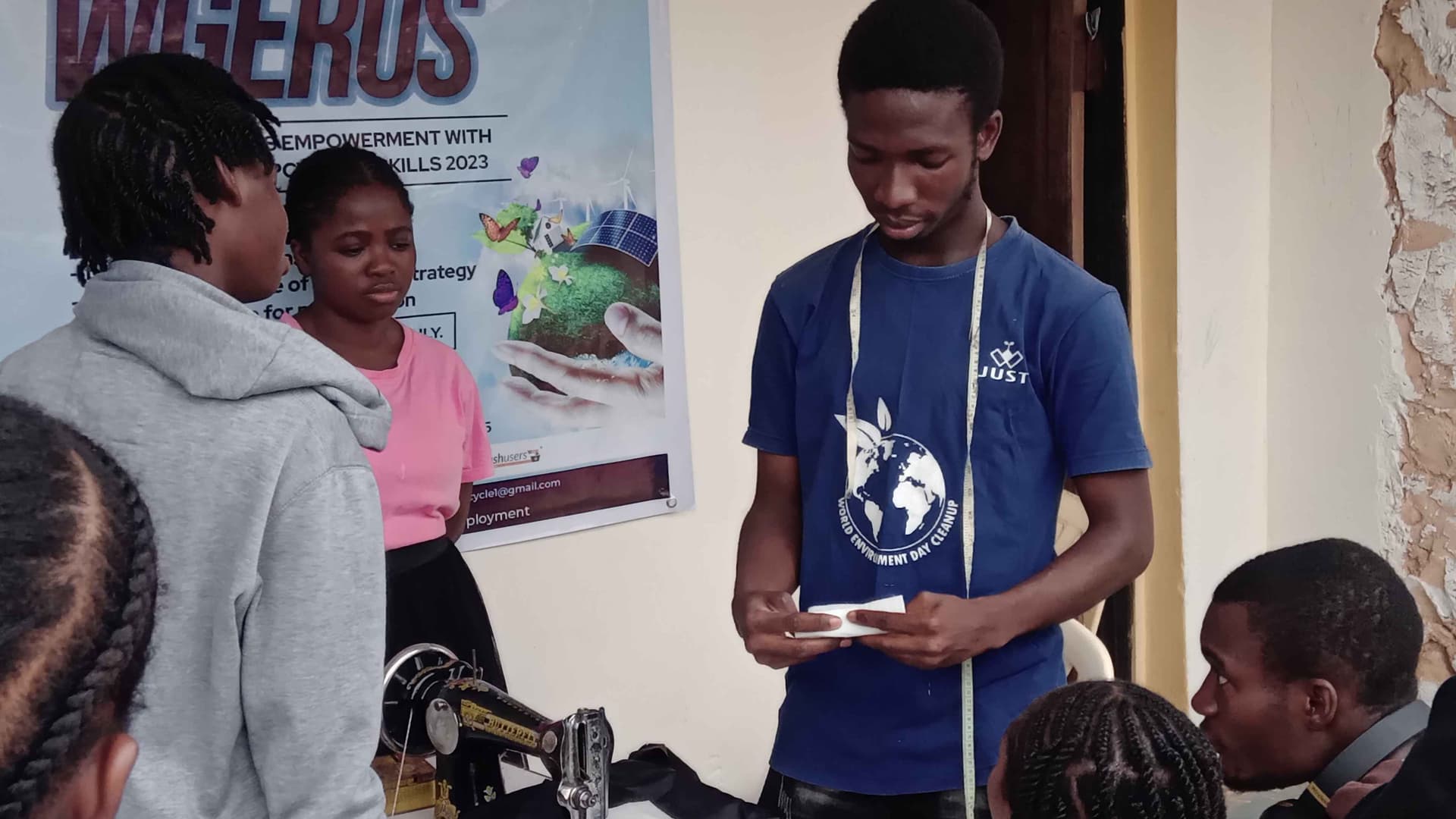 Oyedele Joshua showing participants of Women and Girls Empowerment with Recycling and Upcycling Skills how to couple bag