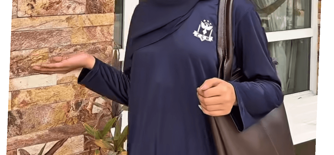 A young girl wearing a dark navy cadet-style uniform, standing outdoors 